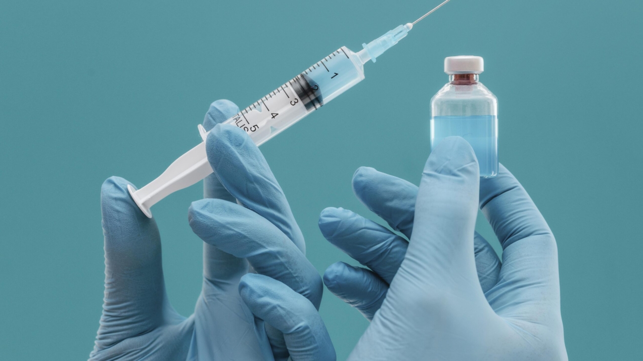 vaccine-bottle-syringe-held-by-doctor-with-gloves