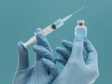 vaccine-bottle-syringe-held-by-doctor-with-gloves