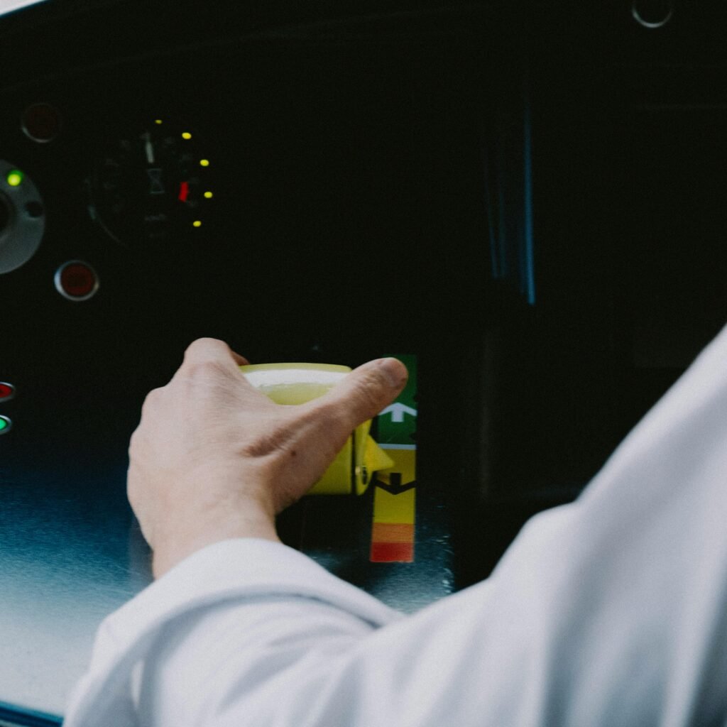 Close-up of a pilot's hand on the control dashboard in a cockpit, showcasing aviation technology.