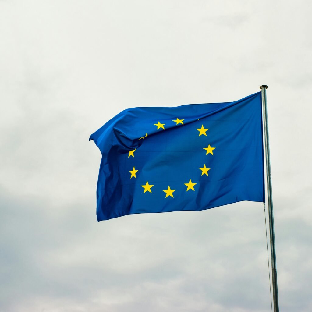 European Union flag waving vividly against a cloudy sky in Strasbourg, France.