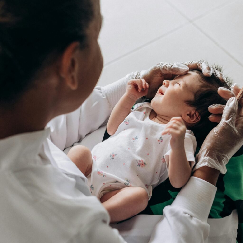 A medical professional examines a newborn baby indoors, highlighting healthcare and care.
