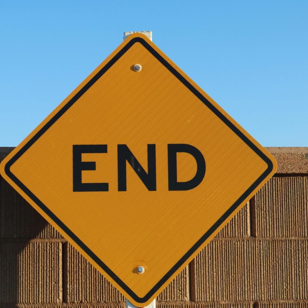 Yellow 'END' sign in Elk Grove, California, with a bright blue sky and brick wall backdrop.