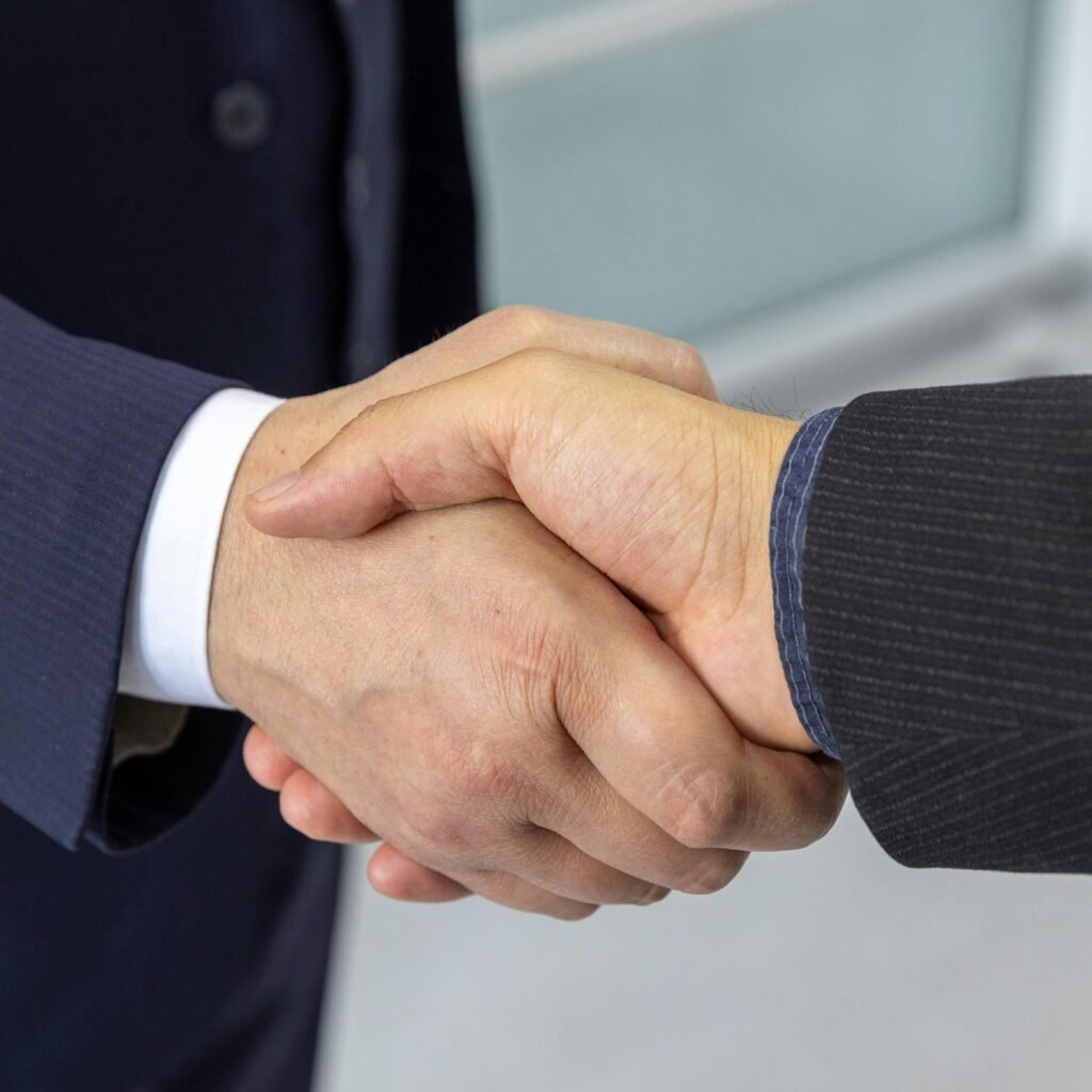 Close-up of two business professionals shaking hands, symbolizing partnership and collaboration.