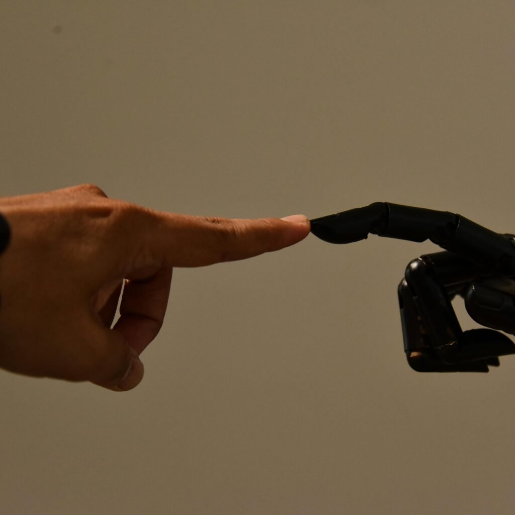 A human hand and a robotic hand extending fingers to touch, symbolizing connection.