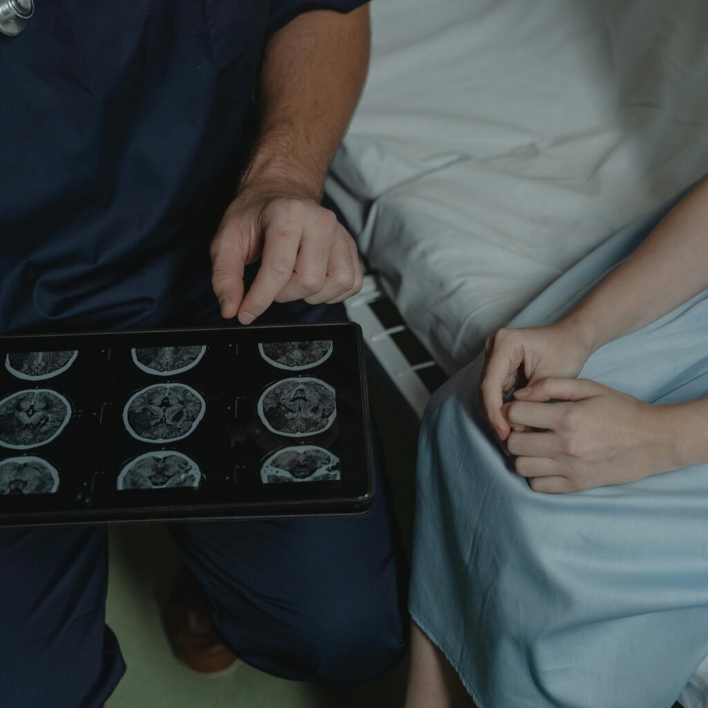 A doctor shows and explains brain scan images to a patient in a medical setting.