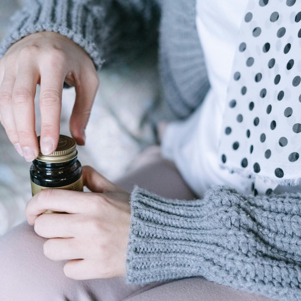 A close-up of hands opening a medicine bottle, emphasizing healthcare and recovery.