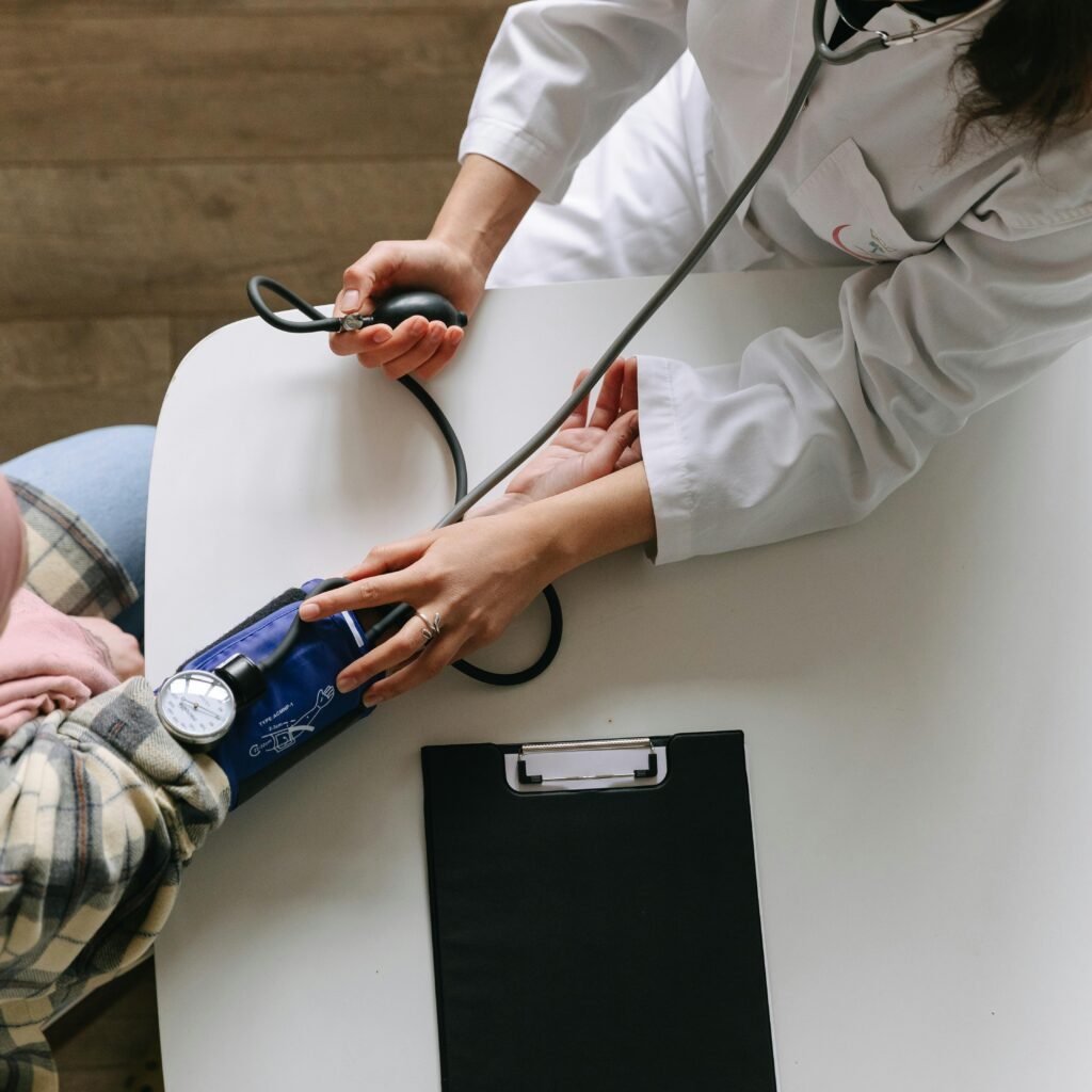 A medical practitioner checks a patient's blood pressure in a clinical setting, showcasing healthcare service.