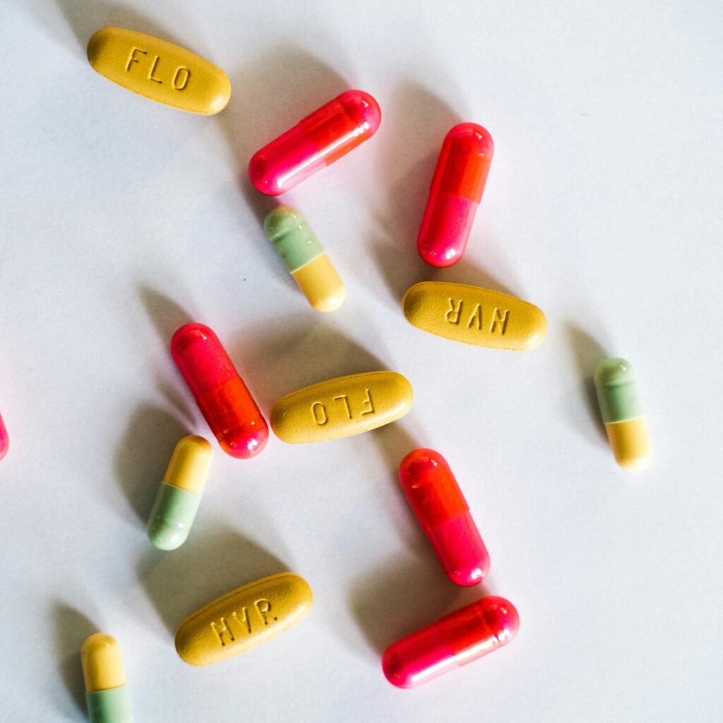 A vibrant assortment of colorful capsules and pills scattered on a white surface.