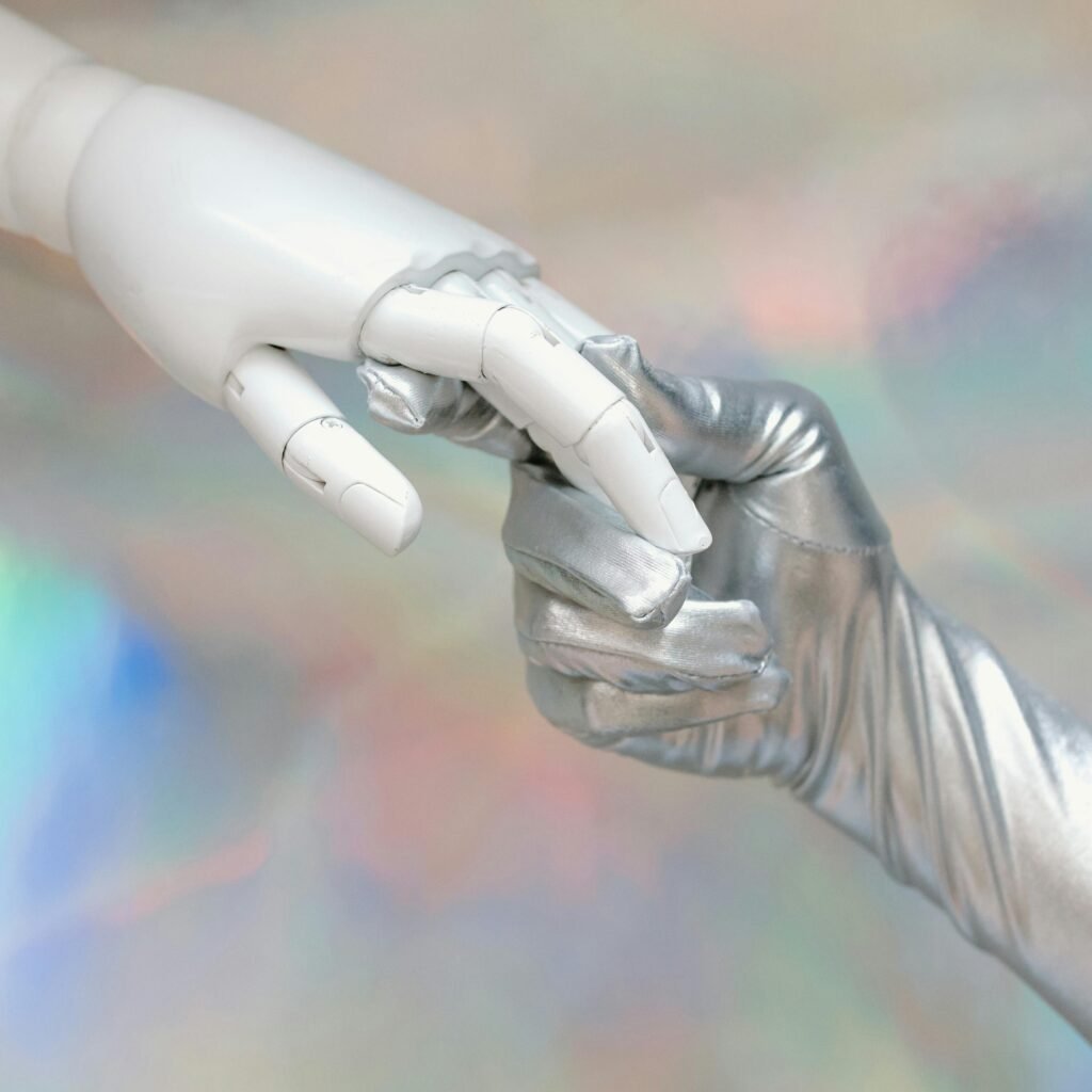 Close-up of a robot hand and silver-gloved hand touching, symbolizing human-robot connection.