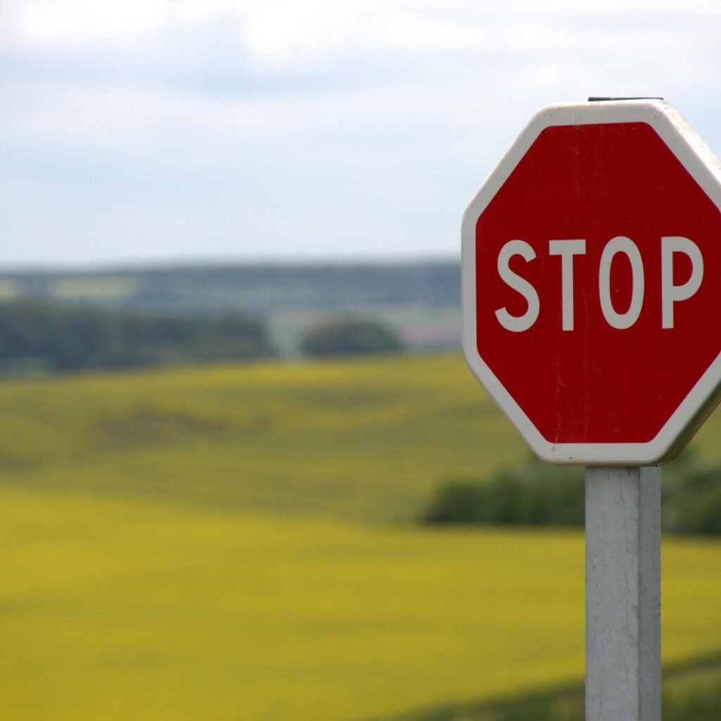 A stop sign stands alone against a rural landscape in Schweyen, France.