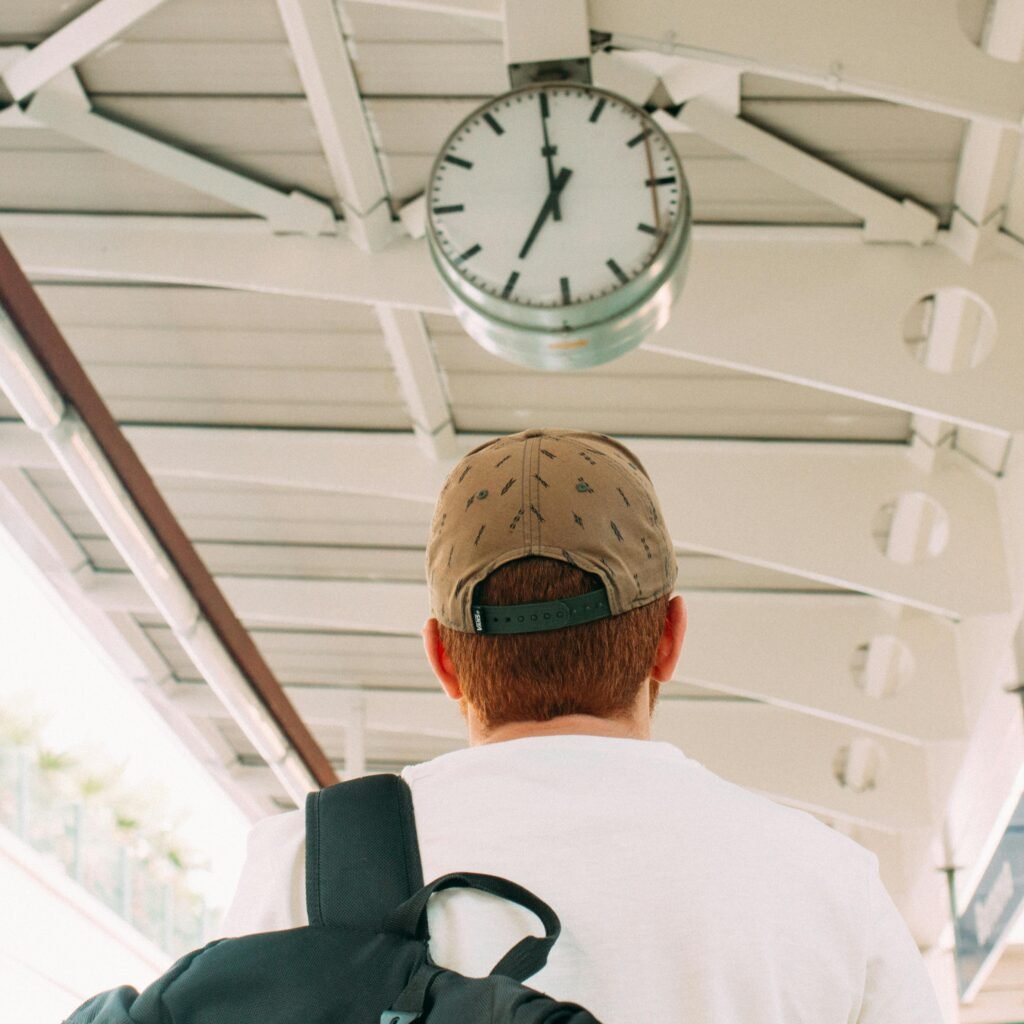 Traveler at a train station platform looking at the clock, anticipating departure.