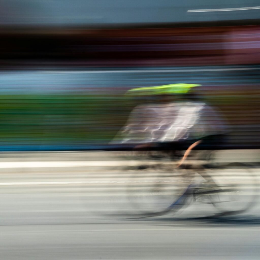 A cyclist in motion creates a blur effect on a sunny day in Mexico City.