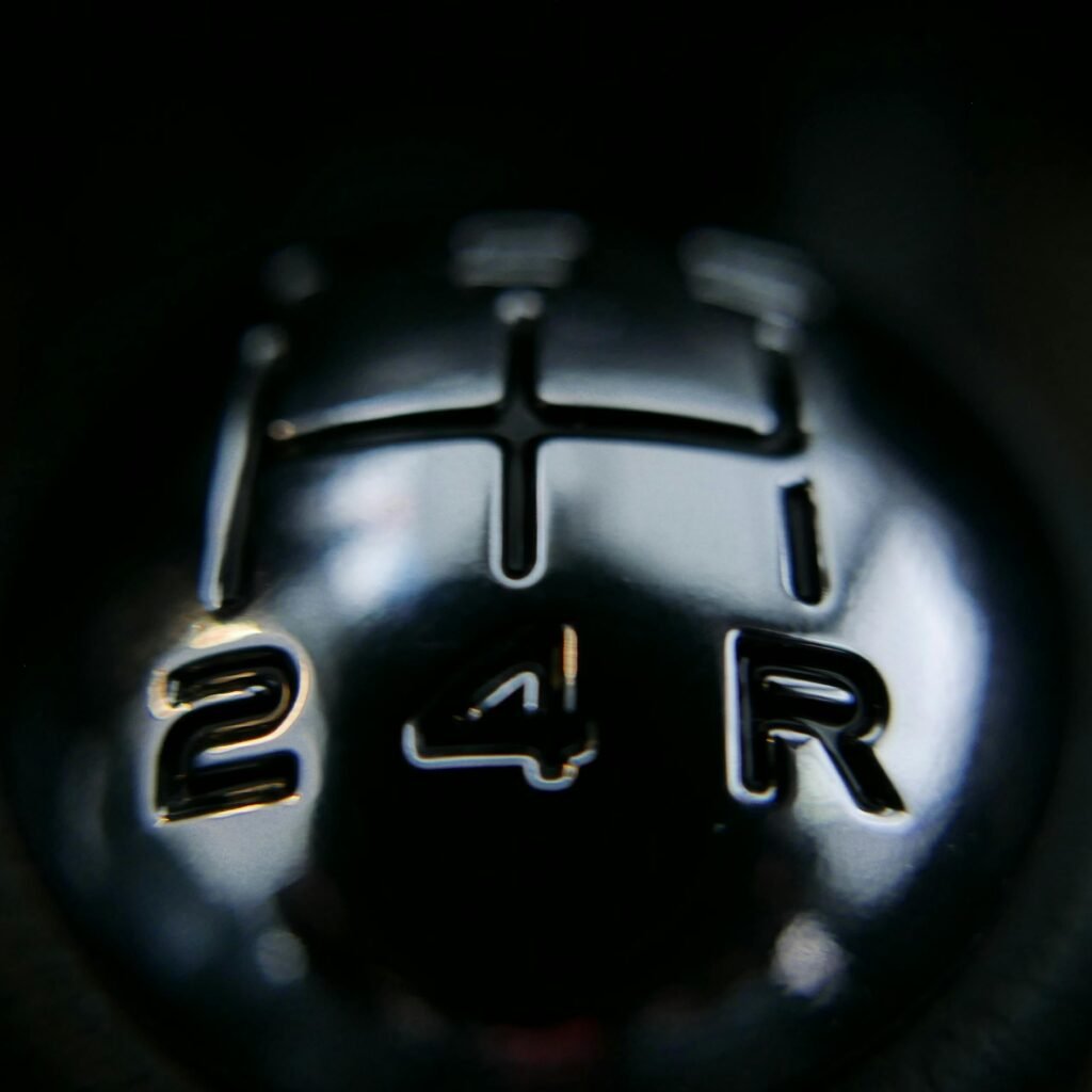 Detailed view of a manual shift knob inside a vehicle, showcasing gear arrangements.