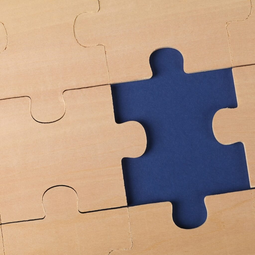 Close-up of an unfinished wooden puzzle with a missing piece, highlighting problem-solving concepts.