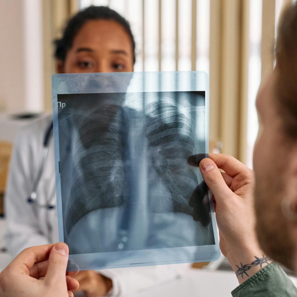 Doctor reviews chest x-ray results with patient in a medical office.
