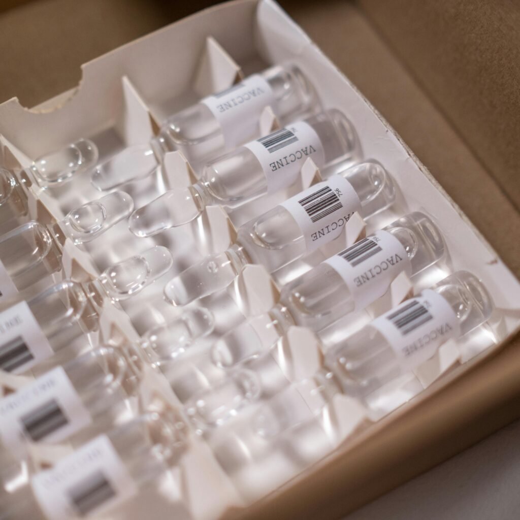 Box of COVID-19 vaccine vials ready for distribution. High-quality stock image for health-related content.