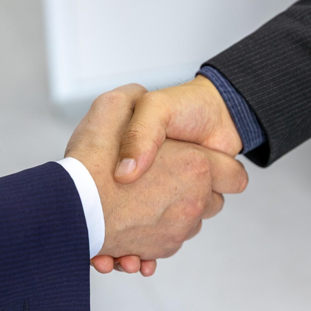 Close-up of two businessmen shaking hands, symbolizing agreement and partnership.