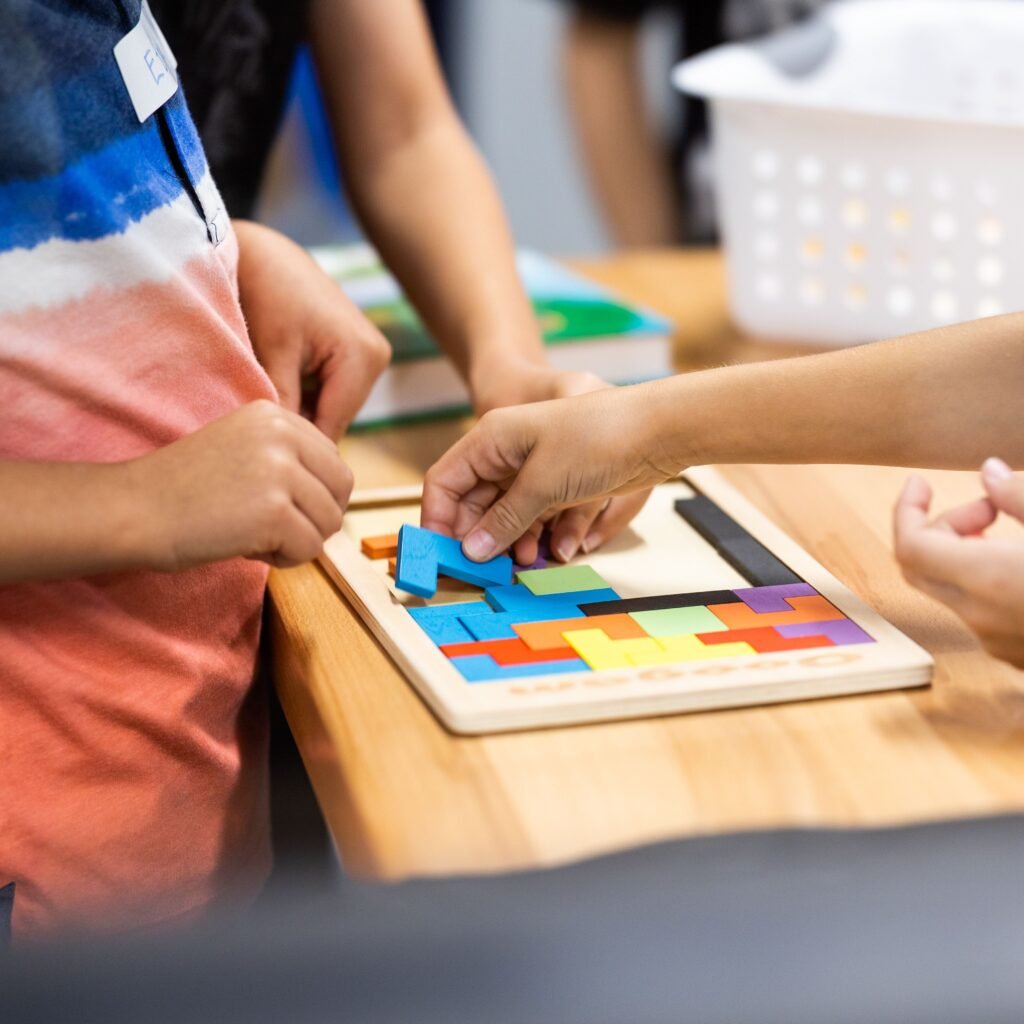 Young children learning with colorful puzzle pieces in a classroom setting.