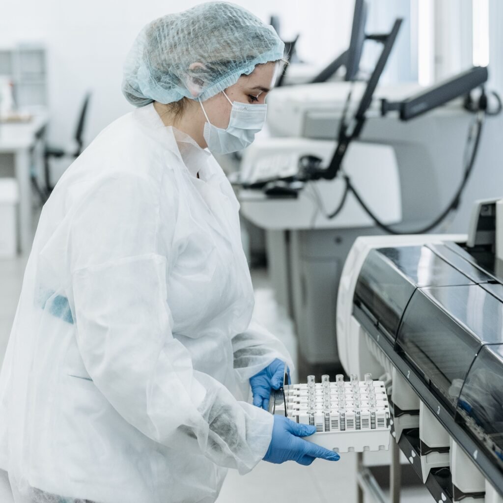 Laboratory scientist in protective gear working with medical samples.