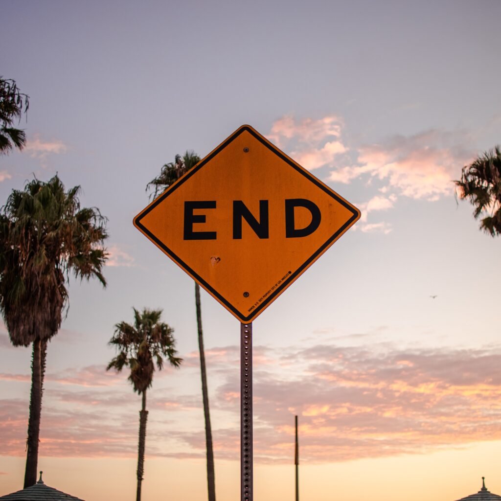 End sign amidst palm trees and sunset sky in Santa Monica, Los Angeles.