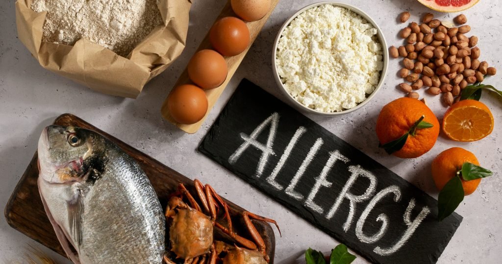 Illustration depicting omalizumab versus multiallergen oral immunotherapy (MOIT) for multifood allergy, highlighting the Phase III OUTMATCH trial that showed improved treatment completion, protection against accidental food exposure, and fewer adverse events with anti-IgE therapy.