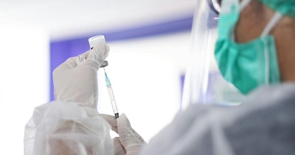 A healthcare worker preparing a syringe with vaccine, showcasing medical precision.