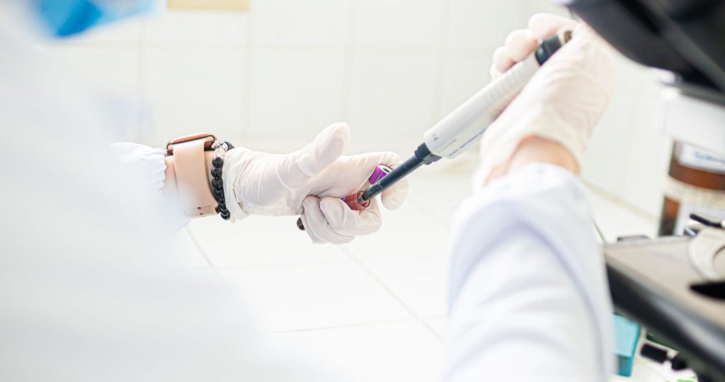 A medical professional using pipette in a lab setting, emphasizing precision and care.