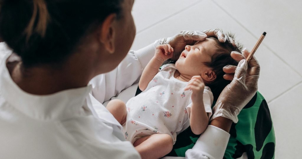 A medical professional examines a newborn baby indoors, highlighting healthcare and care.