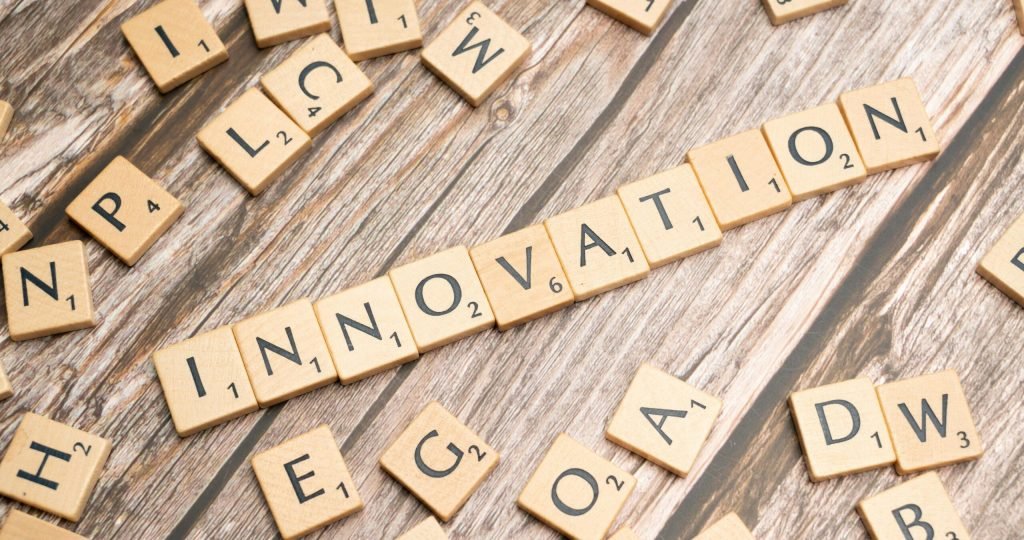 Creative display of 'Innovation' spelled with wooden letter tiles on a wooden surface.
