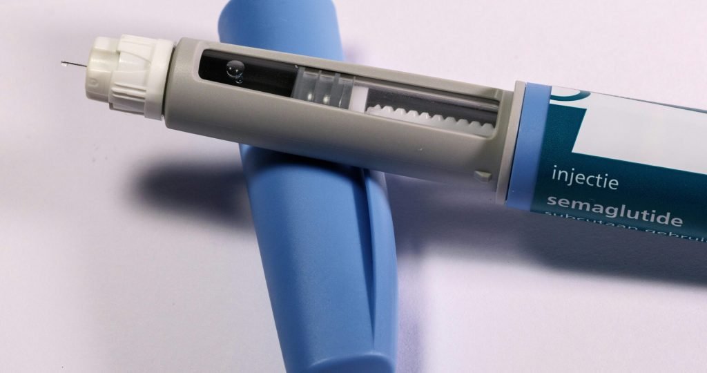 Detailed view of a semaglutide injection pen, commonly used for diabetes treatment, on a plain background.