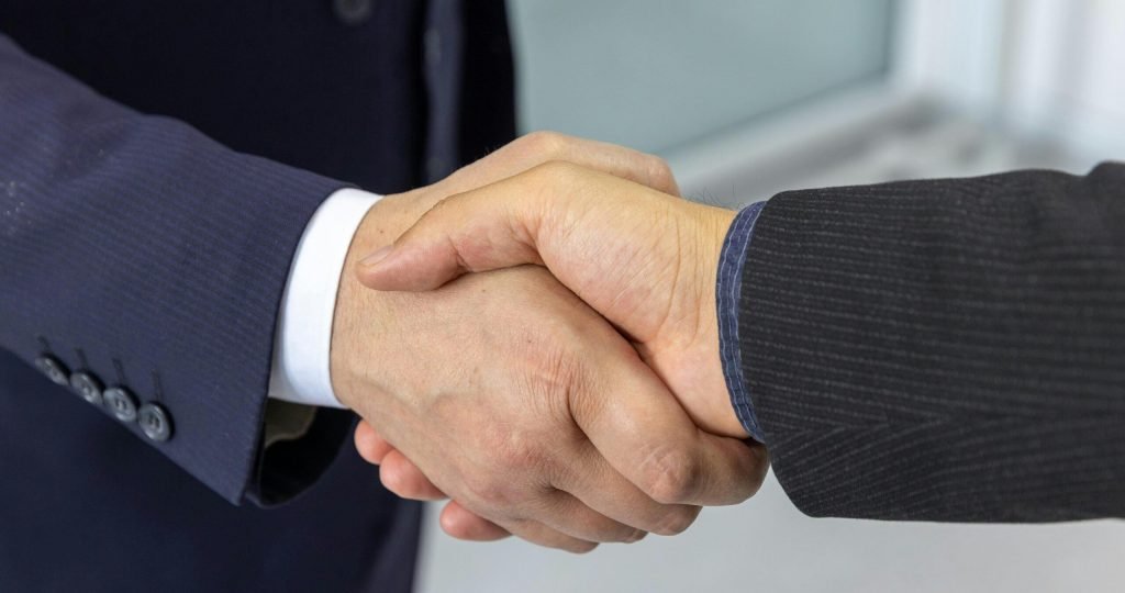 Close-up of two business professionals shaking hands, symbolizing partnership and collaboration.