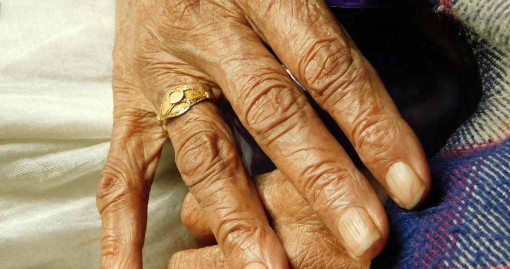 Detailed view of elderly hands with a gold ring, symbolizing wisdom and experience.