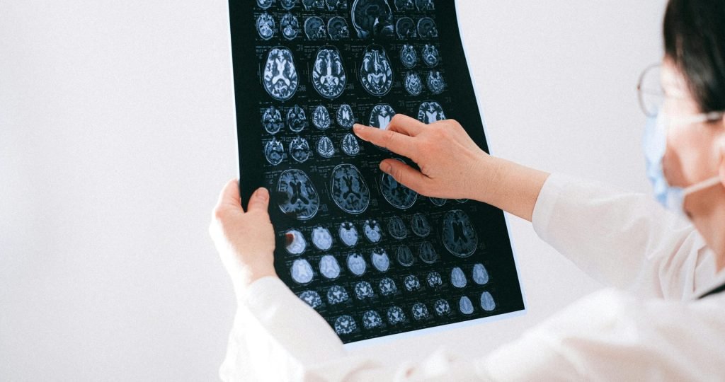 Doctor examines brain MRI scans closely for medical diagnosis in a hospital environment.
