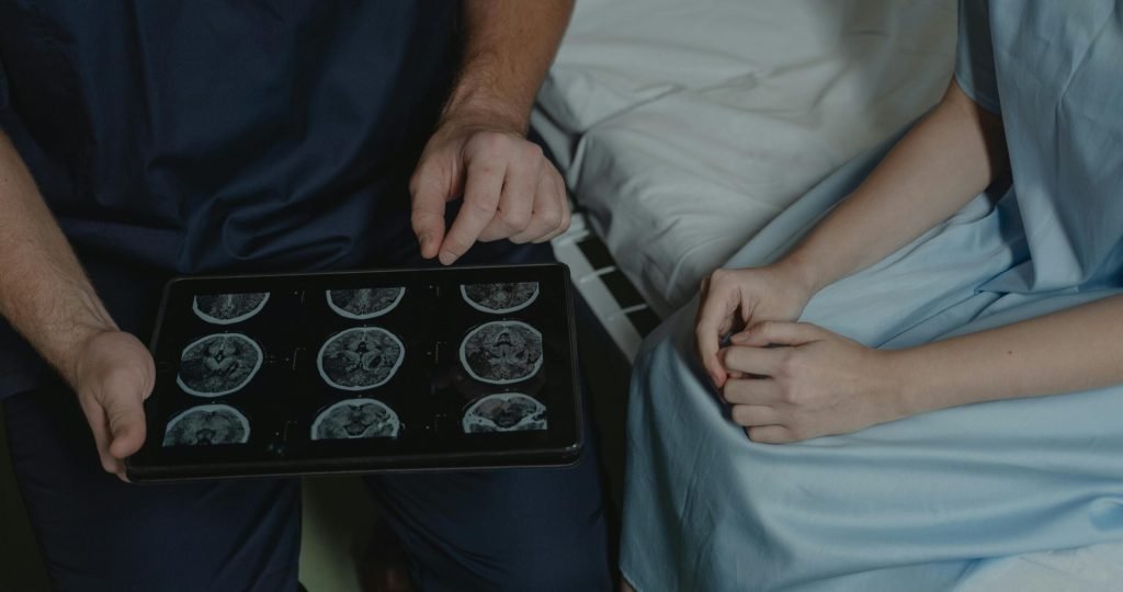 A doctor shows and explains brain scan images to a patient in a medical setting.