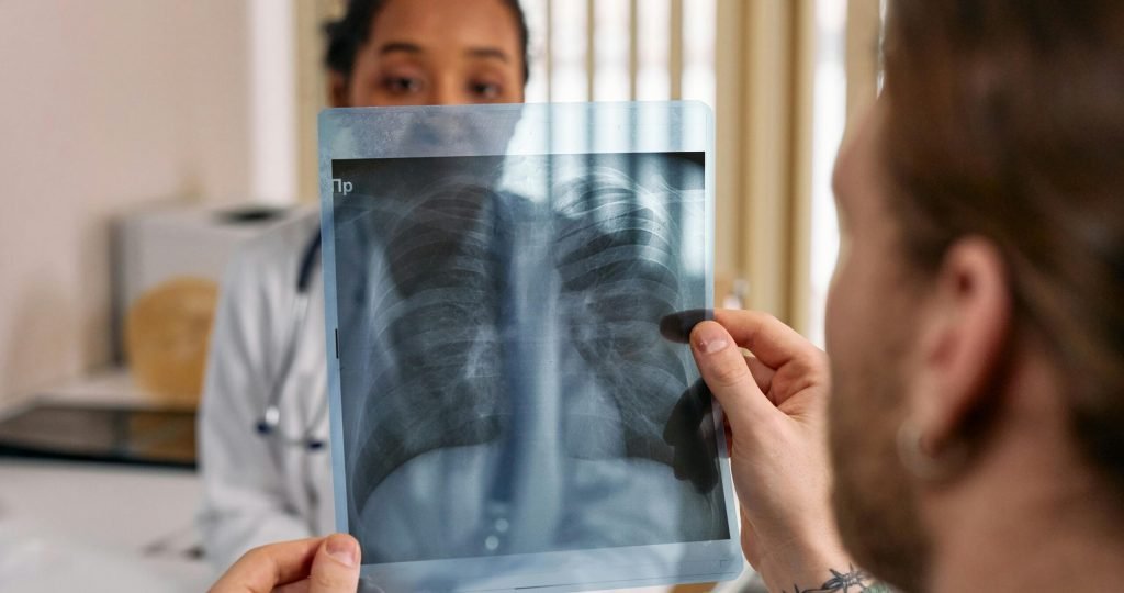 Doctor reviews chest x-ray results with patient in a medical office.