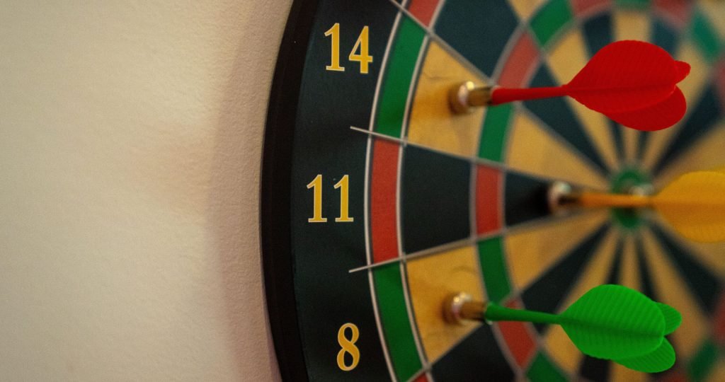 Vivid close-up of a dartboard with multicolored darts accurately striking the target.