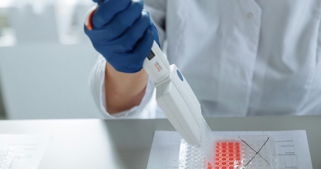 Close-up of a scientist using a pipette in a lab with a focus on sterile procedures.
