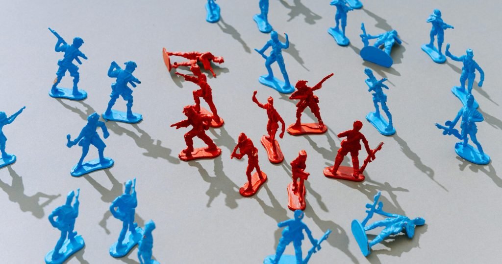 Red and blue toy soldiers on a light surface forming a strategic battle scene.