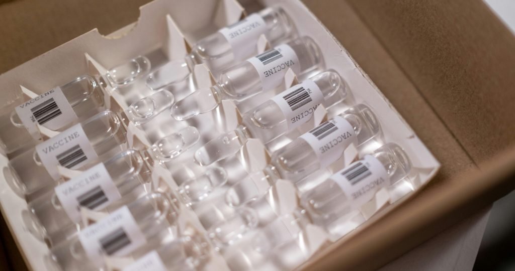 Box of COVID-19 vaccine vials ready for distribution. High-quality stock image for health-related content.