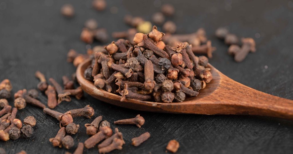 pile-dried-natural-cloves-with-wooden-spoon-black-surface_11zon pile-dried-natural-cloves-with-wooden-spoon-black-surface_11zon