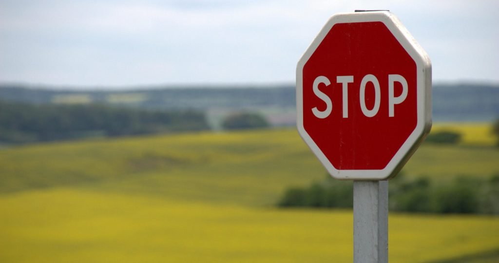 A stop sign stands alone against a rural landscape in Schweyen, France.