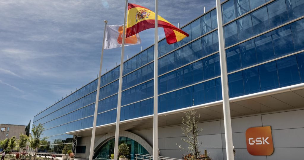 Outside a GSK building with a Spanish and GSK flag in the wind