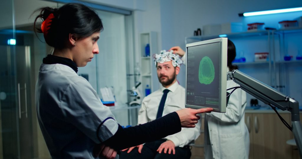 woman-researcher-looking-monitor-analysing-brain-scan-while-coworker-discussing-with-patient-background-about-side-effects_optimized_2000 woman-researcher-looking-monitor-analysing-brain-scan-while-coworker-discussing-with-patient-background-about-side-effects_optimized_2000